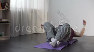 肥胖的男人坐在垫子上，摔倒在地，有趣的胖乎乎的男人在做瑜伽